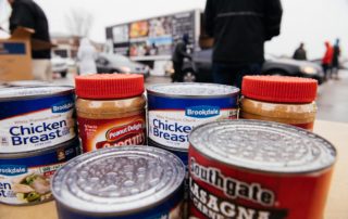 Canned goods and peanut butter are ready to be bagged at a rainy mobile food pantry distribution.