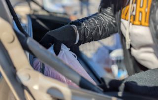 A volunteer loads a car with free food from One Generation Away's mobile food pantry