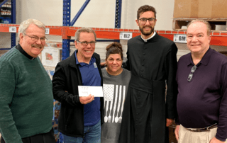 Leaders from St. Philip Catholic Church give a $20,000 check to Chris and Elaine Whitney of OneGenAway