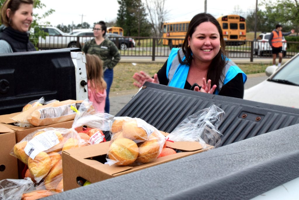 A One Generation Away volunteer loads up a pickup truck with food at a mobile food pantry distribution.