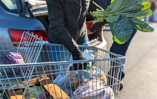 A volunteer loads a car with groceries at OneGenAway's mobile food pantry.
