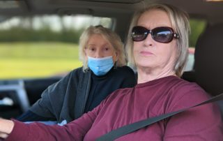 Susan and Anne sat in their car to wait in line for food at a OneGenAway mobile food pantry distribution.