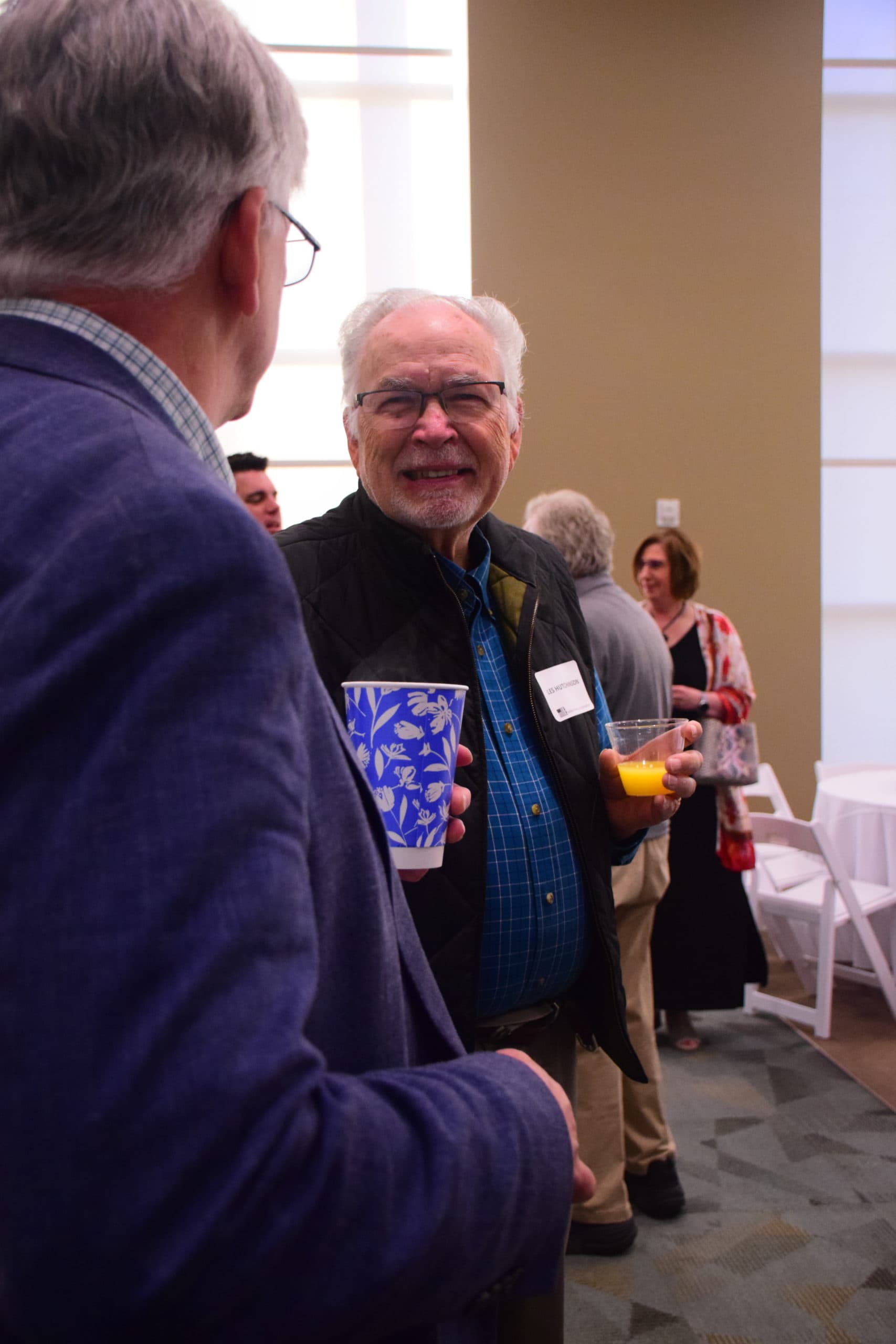 Les Hutchinson chats by the breakfast bar at OneGenAway's 2022 Million Meal Spring Breakfast.