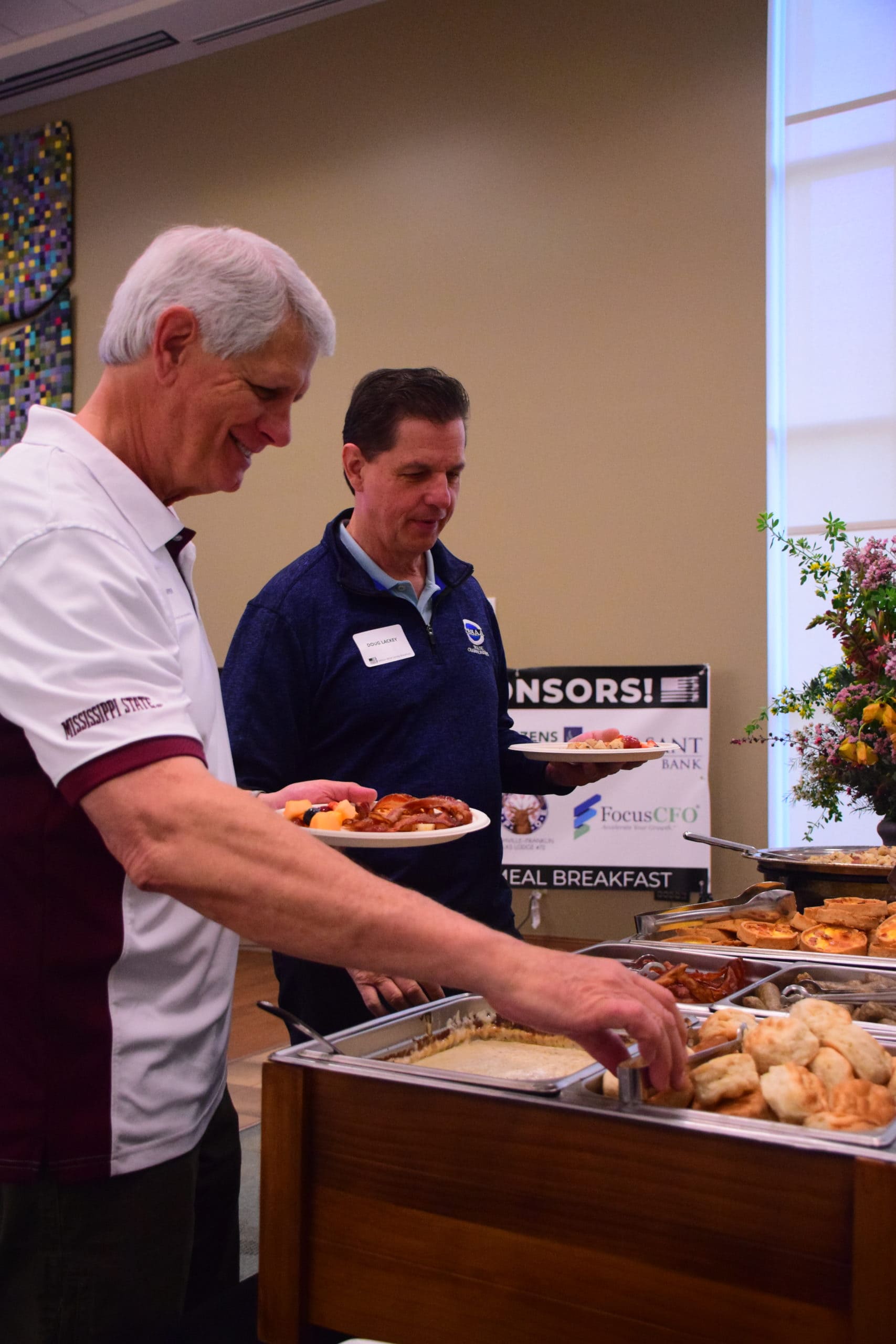 Attendees at the 2022 Million Meal Spring Breakfast load their plates with food by Catering and Events by Suzette.