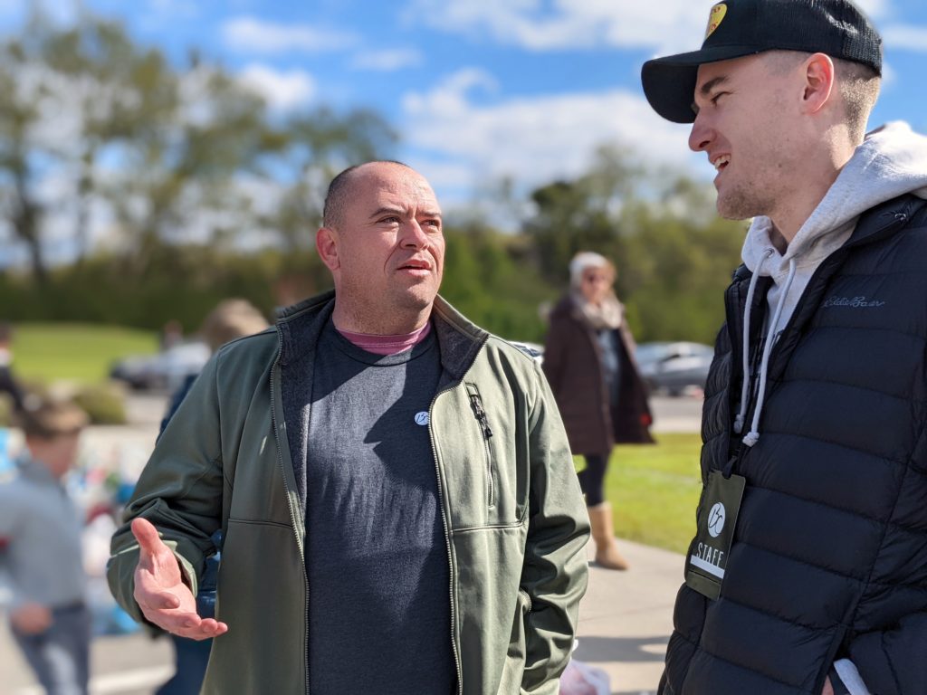 Tim chats with a volunteer at OneGenAway's mobile food pantry.