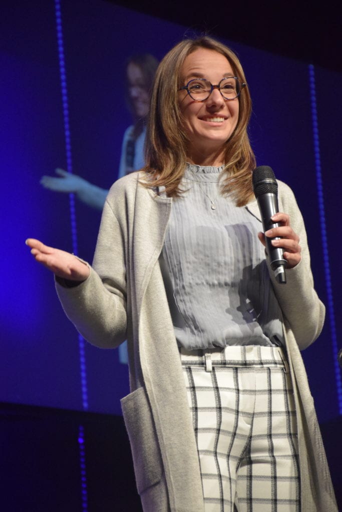 Daelyn Houser speaks on stage at OneGenAway's Million Meal Spring Breakfast in Alabama.